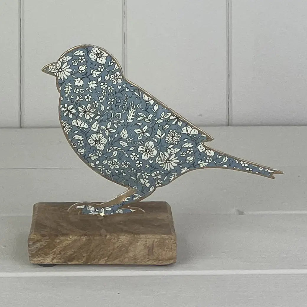 Blå metallfugl på trebunn