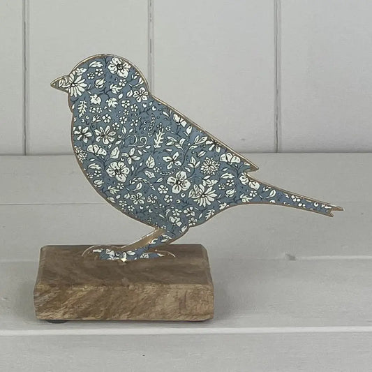 Blå metallfugl på trebunn