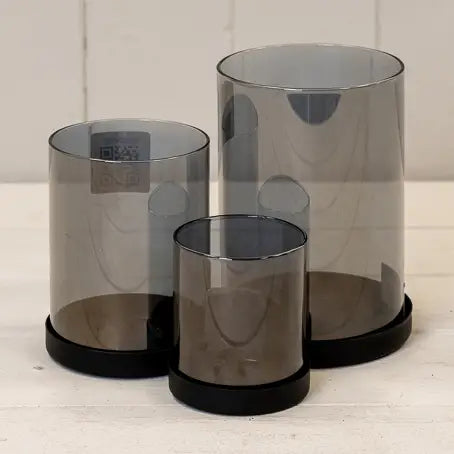 Sett med tre sorte lysestaker i glass med metallbase